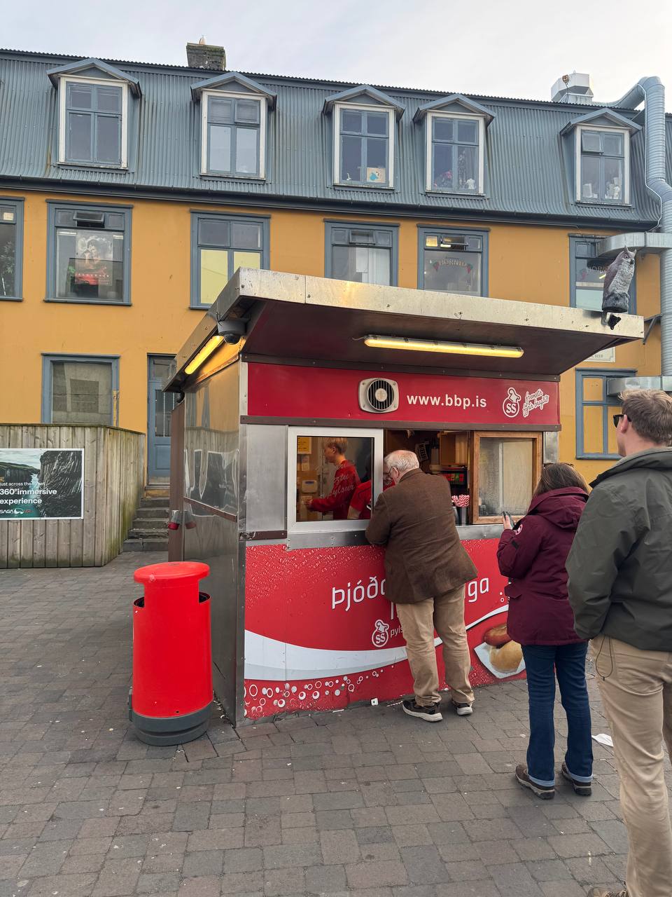 Famous Bæjarins Beztu Pylsur hot dog stand in Reykjavik with guests lining up during a Reykjavik Food Tours tasting tour with our agency