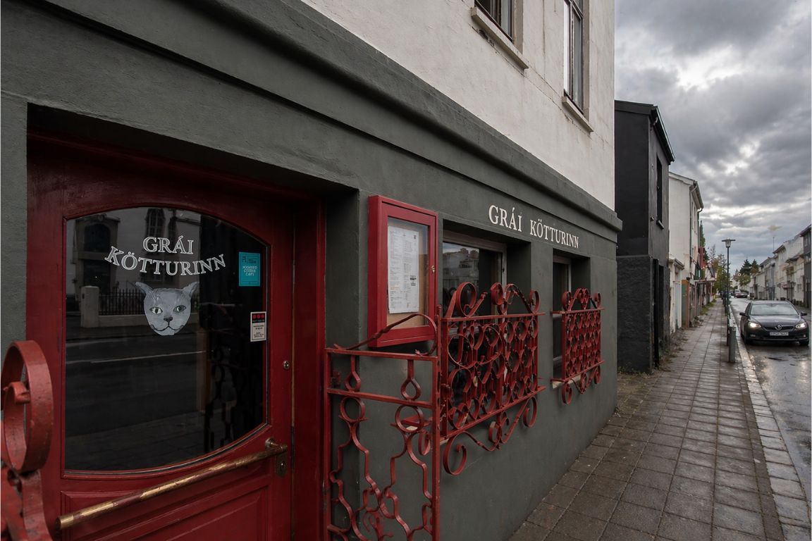 Grái Kötturinn restaurant exterior in Reykjavik with red door and signage visited during a Reykjavik Food Tours experience with our agency